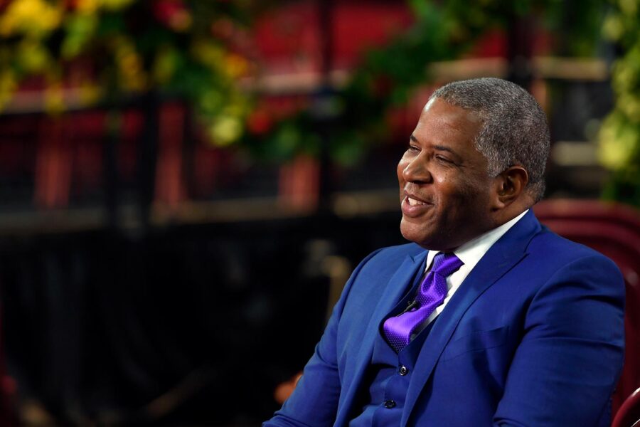 Side profile of Robert F. Smith wearing a blue suit with a purple tie.